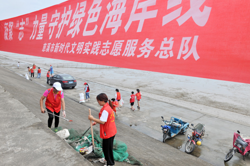 6月13日，慈溪市新时代文明实践志愿服务总队组织80余名环保志愿者在海岸线半掘西的海涂上清理垃圾.jpg